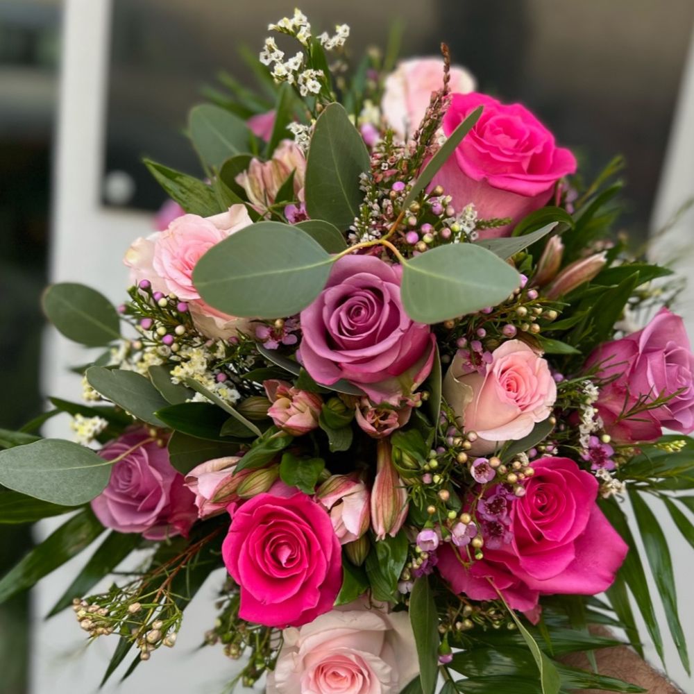 Hermoso ramo de distintas rosas rojas y rosadas con hojas verdes