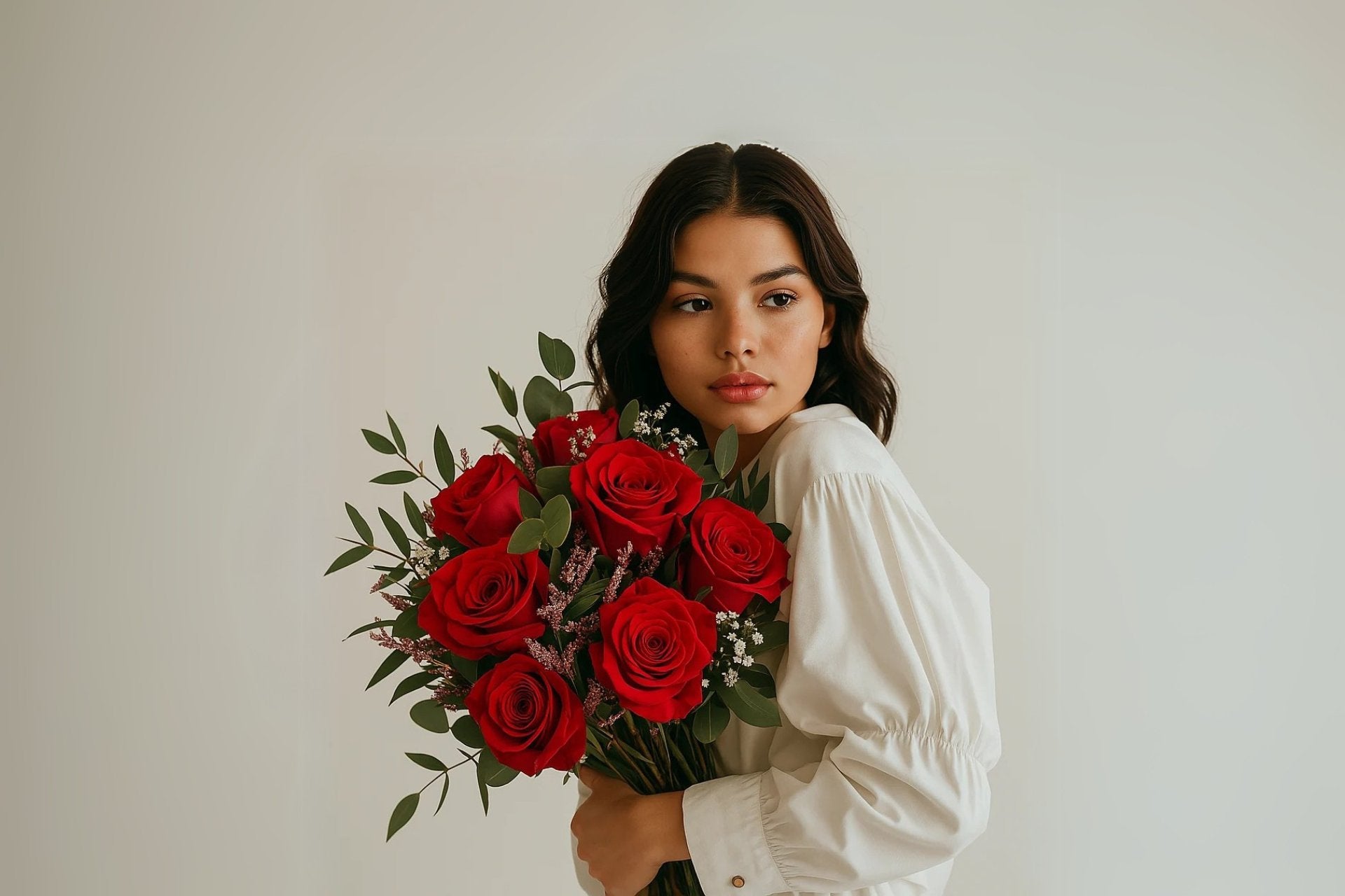 joven morena sosteniendo un ramo de rosas rojas para san valentin de persa flores