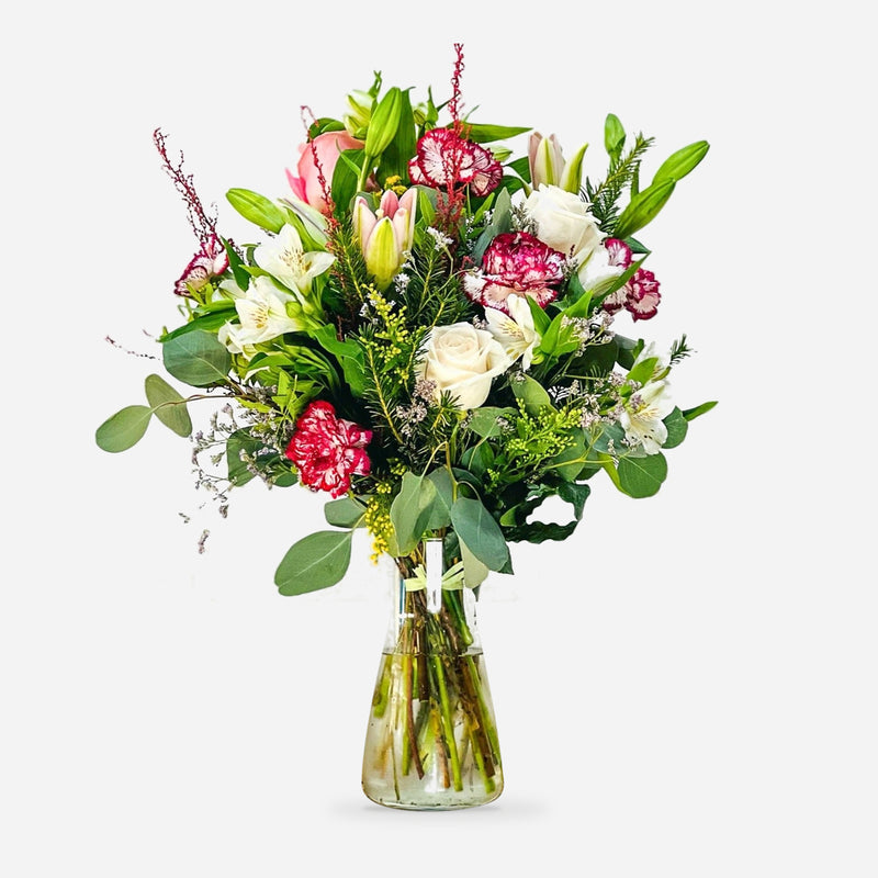Ramo Nadia con rosas blancas y rosadas, capullos de lirio, alstroemerias y claveles bicolores en jarrón de cristal.